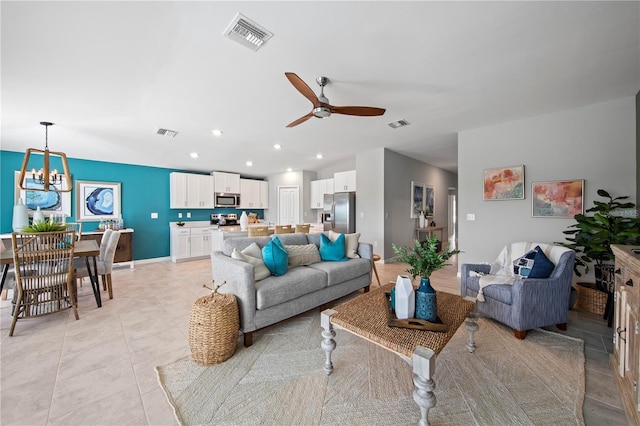 living room featuring ceiling fan with notable chandelier