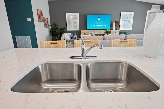 interior details with light stone countertops and sink