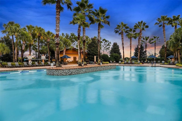 pool at dusk featuring a patio area