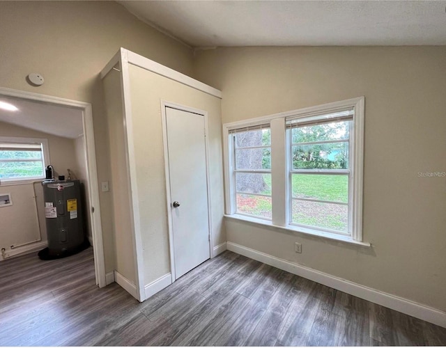 unfurnished bedroom with wood-type flooring, vaulted ceiling, and water heater