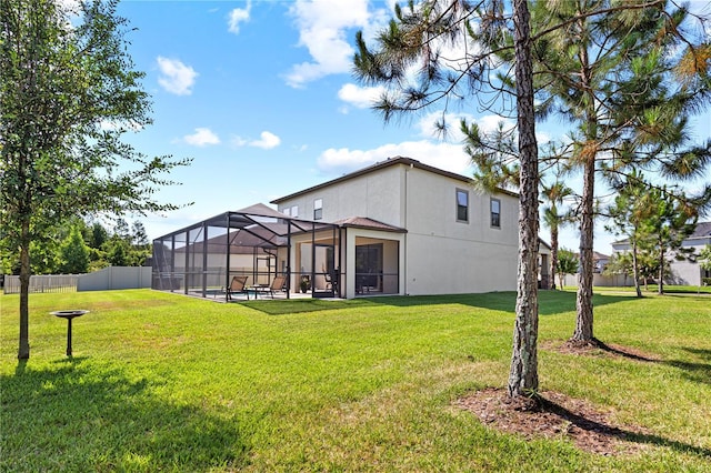 back of property with glass enclosure, a pool, and a yard