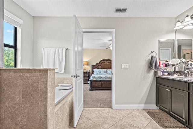 bathroom with vanity, a relaxing tiled tub, tile patterned floors, and ceiling fan