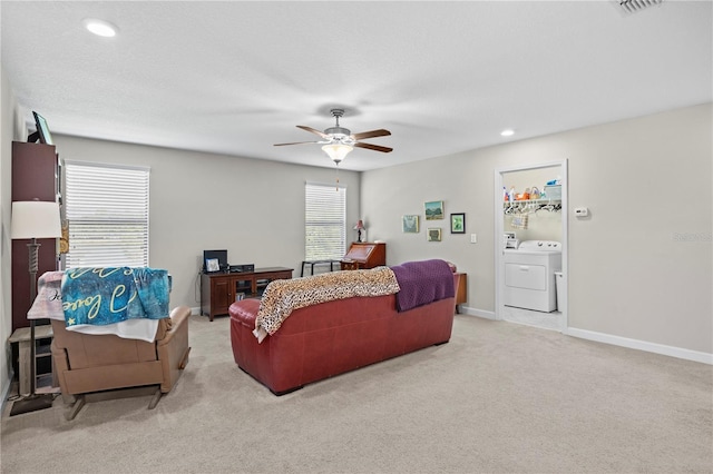 living room featuring light carpet, ceiling fan, and washing machine and clothes dryer