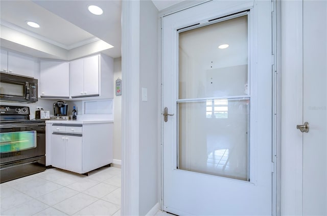 kitchen with white cabinetry, light tile patterned flooring, black appliances, and ornamental molding