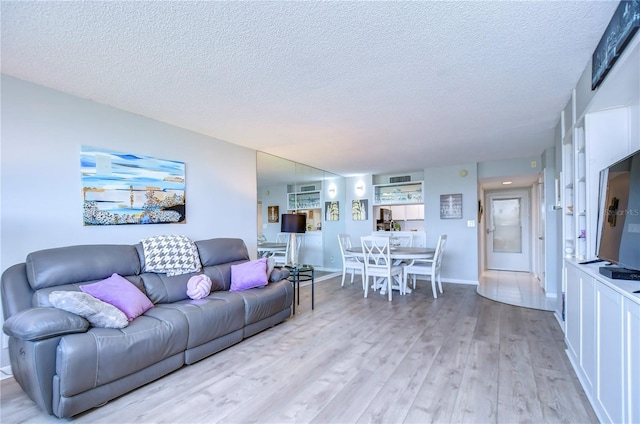 living room with light hardwood / wood-style floors and a textured ceiling