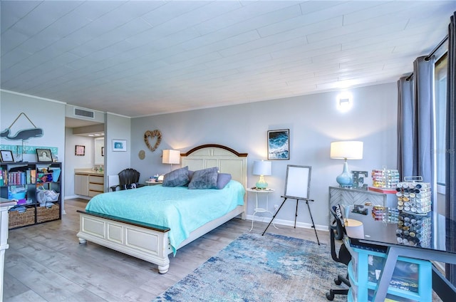 bedroom with light hardwood / wood-style floors and crown molding