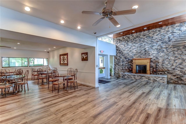 dining area featuring a fireplace, ceiling fan, and light hardwood / wood-style flooring