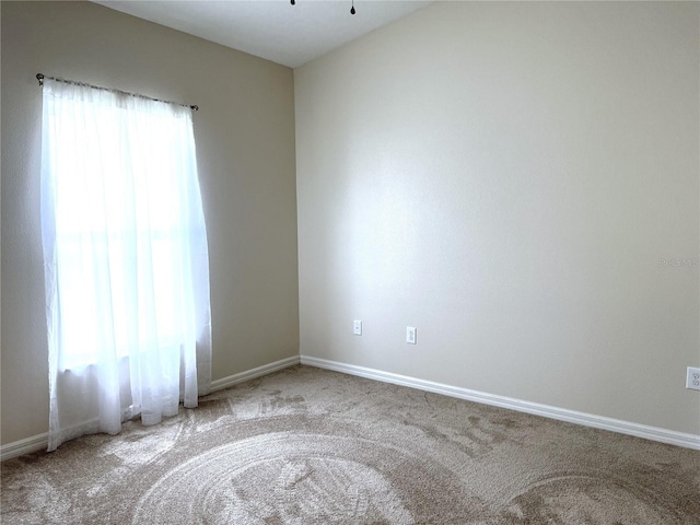 spare room with carpet and baseboards