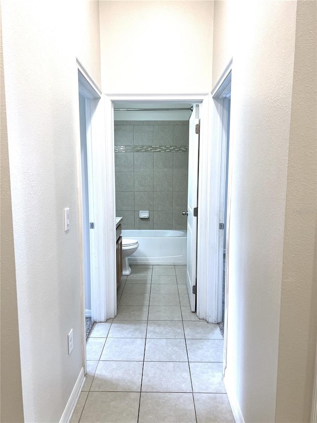 hallway featuring light tile patterned floors and baseboards