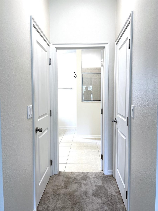 corridor featuring tile patterned floors and carpet floors