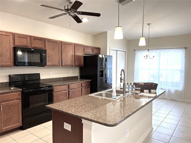 kitchen featuring light tile patterned flooring, hanging light fixtures, black appliances, and a sink