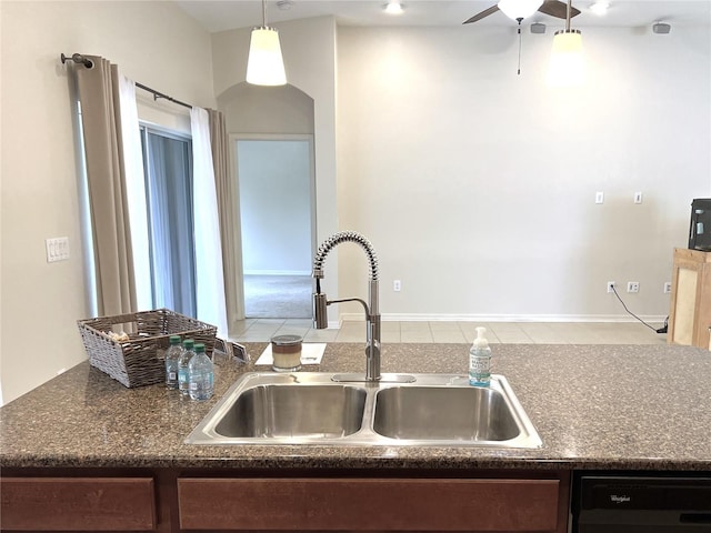 kitchen with dishwasher, dark countertops, a ceiling fan, and a sink