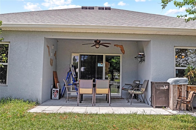 exterior space featuring a patio area, a ceiling fan, stucco siding, and a shingled roof