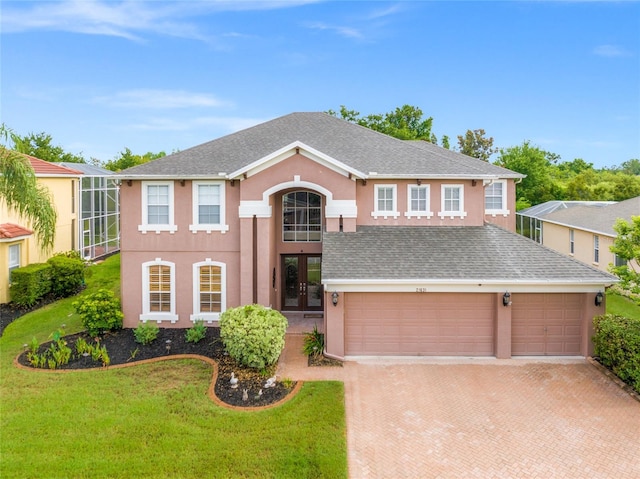 view of front of property featuring a garage, a front yard, and french doors