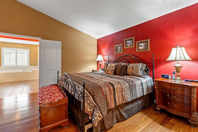 bedroom featuring wood-type flooring and vaulted ceiling