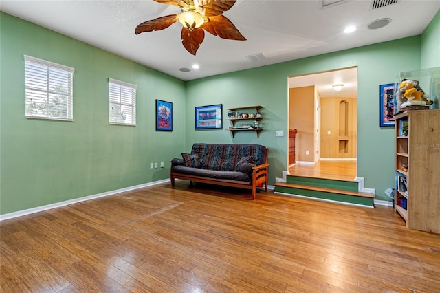 sitting room with ceiling fan and light wood-type flooring