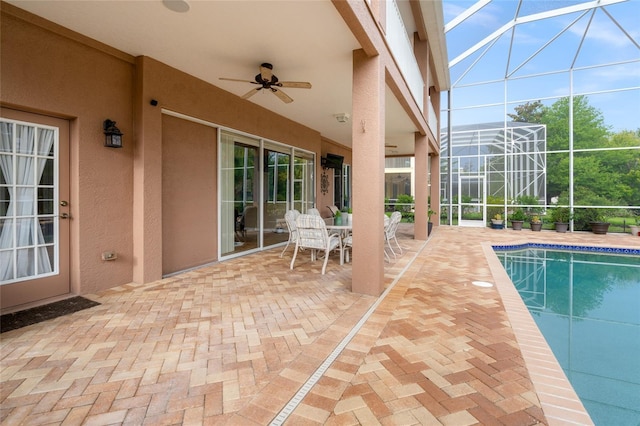 view of swimming pool with ceiling fan, a patio area, and a lanai