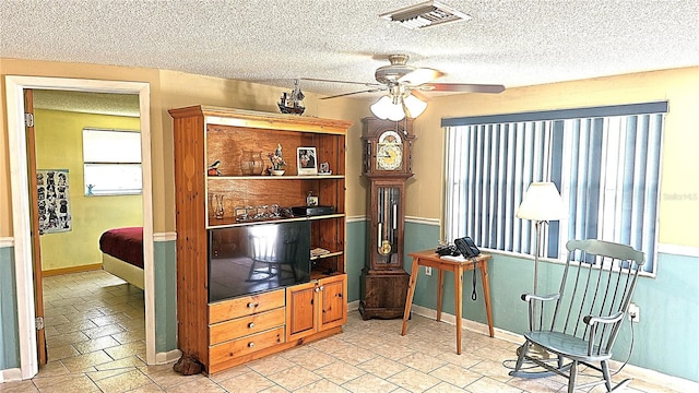 living room with a textured ceiling and ceiling fan