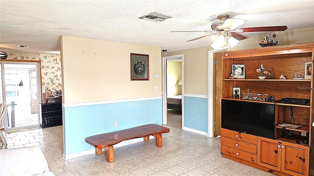 interior space featuring a textured ceiling and ceiling fan