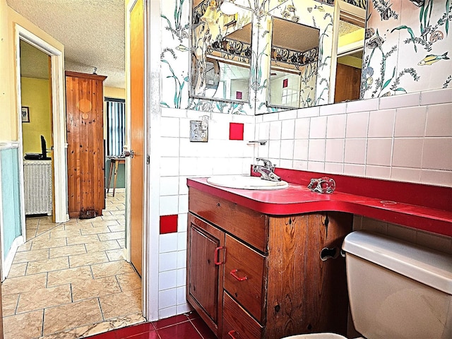 bathroom featuring a textured ceiling, toilet, tasteful backsplash, and vanity