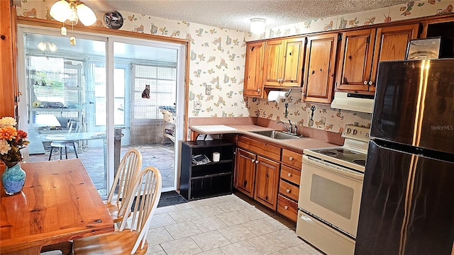 kitchen featuring sink, white electric range oven, a textured ceiling, light tile patterned floors, and stainless steel fridge