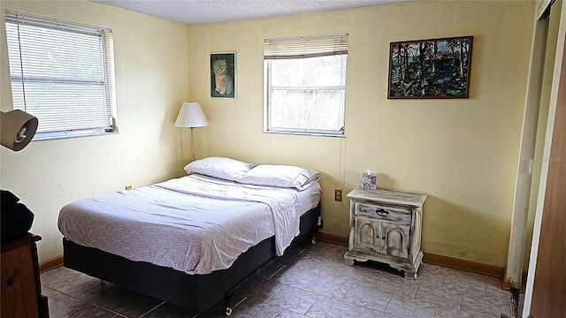 bedroom featuring multiple windows and a textured ceiling