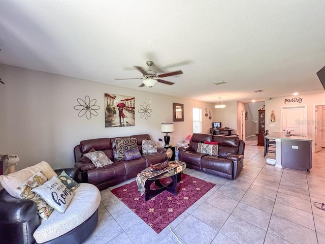 living room featuring light tile patterned floors, ceiling fan, and sink