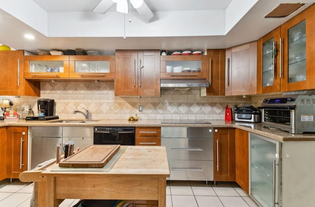 kitchen featuring backsplash, sink, light tile patterned flooring, and black appliances