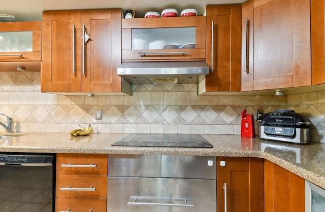 kitchen featuring black appliances, decorative backsplash, light stone countertops, and sink