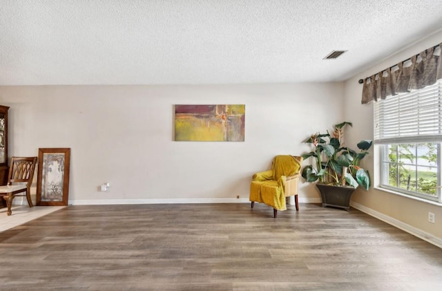 sitting room featuring hardwood / wood-style flooring and a textured ceiling