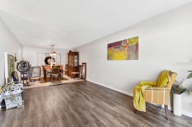 sitting room with dark wood-type flooring and a textured ceiling