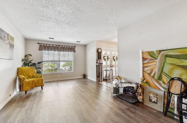 living area featuring hardwood / wood-style flooring and a textured ceiling