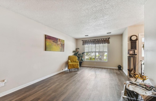 sitting room with a textured ceiling and dark hardwood / wood-style floors