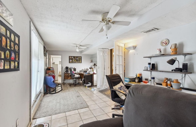 tiled office space with ceiling fan and a textured ceiling