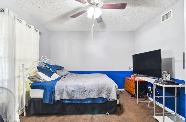 bedroom with ceiling fan, carpet floors, and a textured ceiling