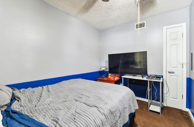 bedroom featuring dark colored carpet and a textured ceiling