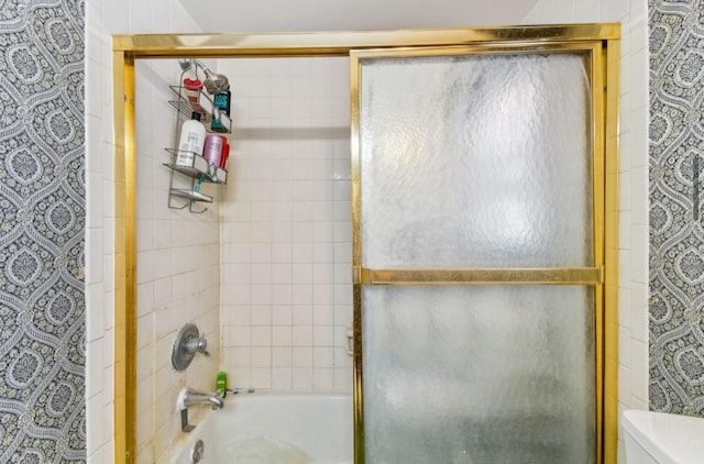 bathroom with bath / shower combo with glass door and toilet