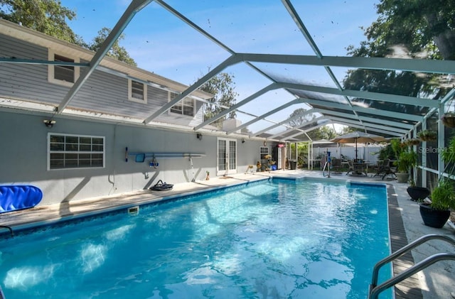 view of pool featuring french doors, glass enclosure, and a patio area