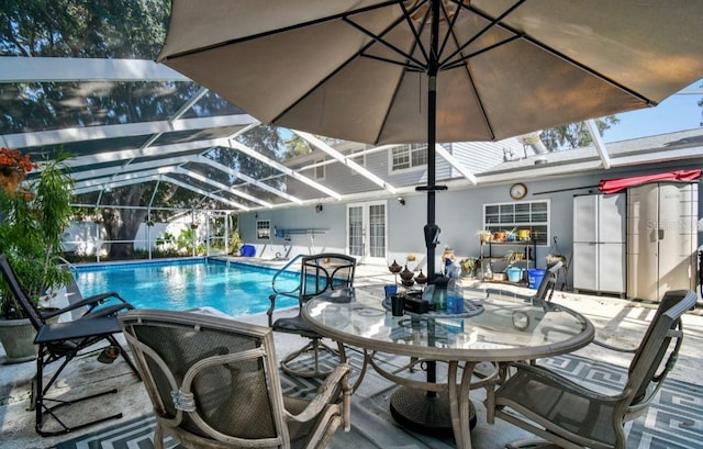 view of pool featuring french doors, glass enclosure, and a patio area