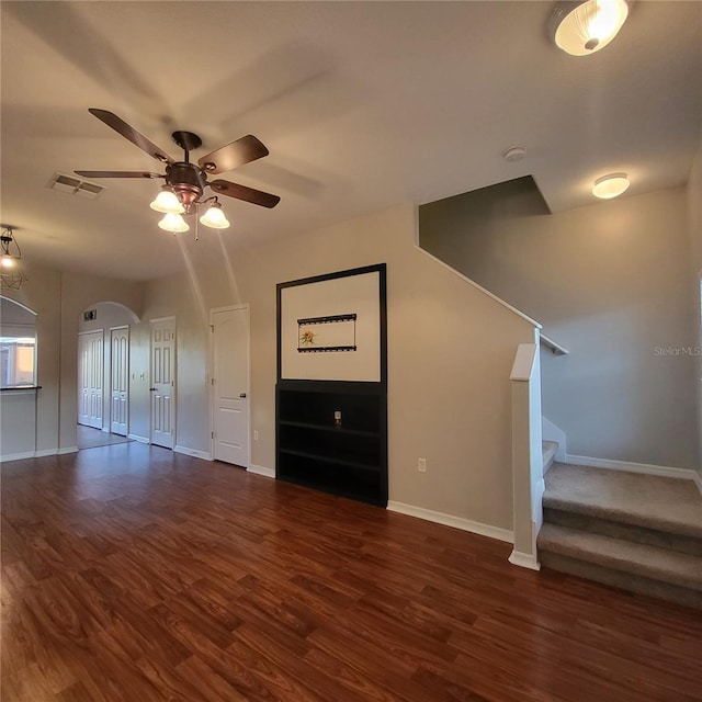 unfurnished living room featuring ceiling fan and dark wood-type flooring