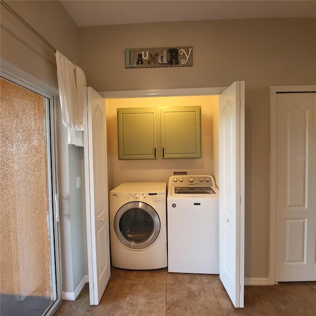 laundry room featuring washer and dryer, cabinets, and light tile patterned floors