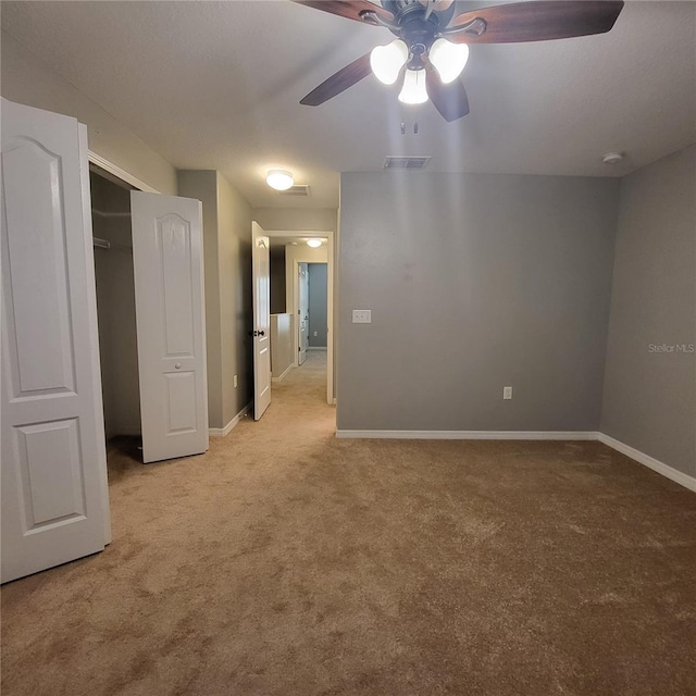 unfurnished bedroom featuring a closet, ceiling fan, and light carpet