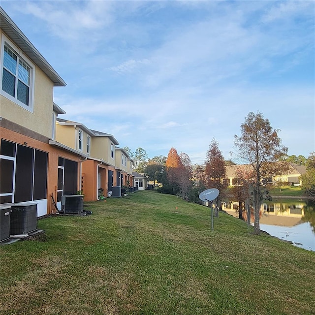 view of yard with a water view and central AC unit