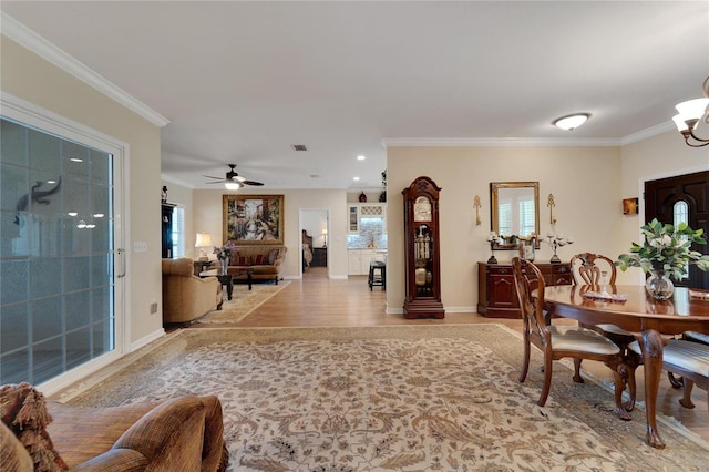 2628 River Bend Dr, Ruskin, FL 33570 - dining room featuring ceiling fan with notable chandelier, light hardwood / wood-style floors, and ornamental molding