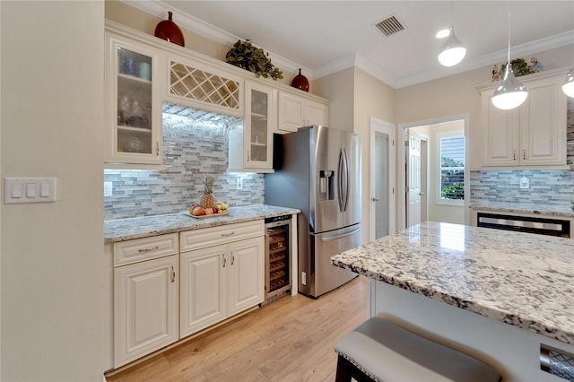 2628 River Bend Dr, Ruskin, FL 33570 - kitchen featuring white cabinets, stainless steel refrigerator with ice dispenser, hanging light fixtures, light stone counters, and beverage cooler