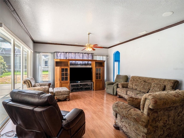 living room featuring crown molding, ceiling fan, a textured ceiling, and light wood-type flooring