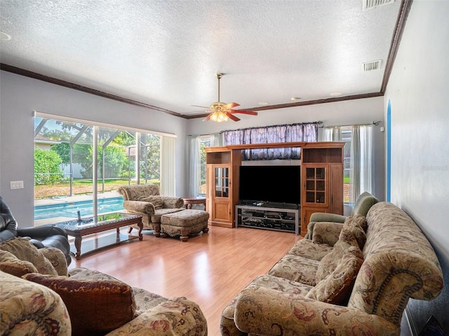 living room featuring hardwood / wood-style flooring, ceiling fan, and a textured ceiling