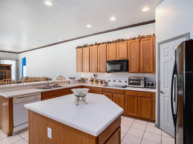 kitchen featuring light tile patterned flooring, sink, a kitchen island, and black appliances