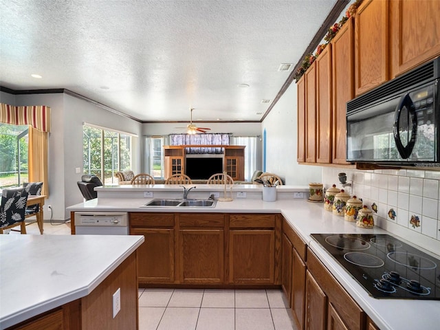 kitchen with black appliances, crown molding, sink, a textured ceiling, and kitchen peninsula