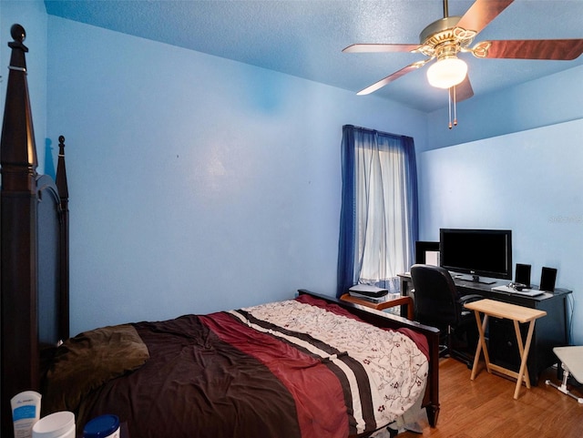 bedroom featuring hardwood / wood-style flooring, ceiling fan, and a textured ceiling